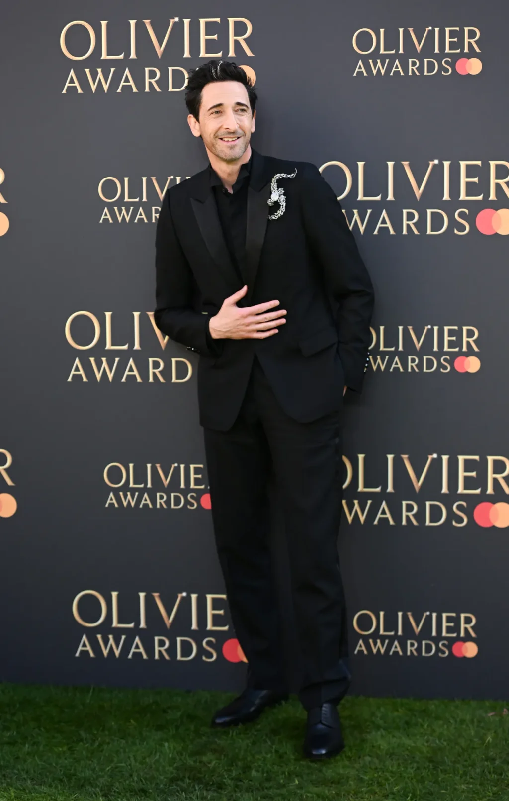 Adrien Brody in a Dior black wool and silk tuxedo with a dragon brooch at the 2025 Olivier Awards