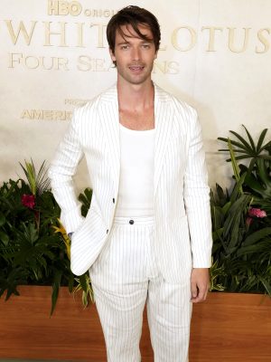 Patrick Schwarzenegger in a white pinstriped Tommy Hilfiger suit, white tank top, and brown shoes at The White Lotus Season 3 finale.