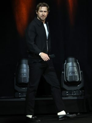 Ryan Gosling walks on stage in an all-black Gucci outfit featuring a zip-up jacket, trousers, and black Horsebit loafers with white socks at CinemaCon 2025.