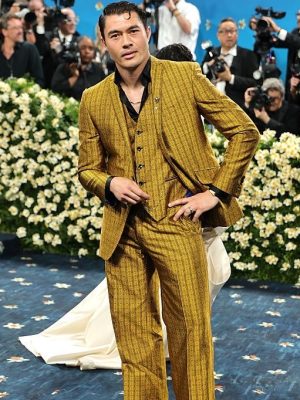Henry Golding posing on the red carpet in his gold Ozwald Boateng suit at the 2025 Met Gala.